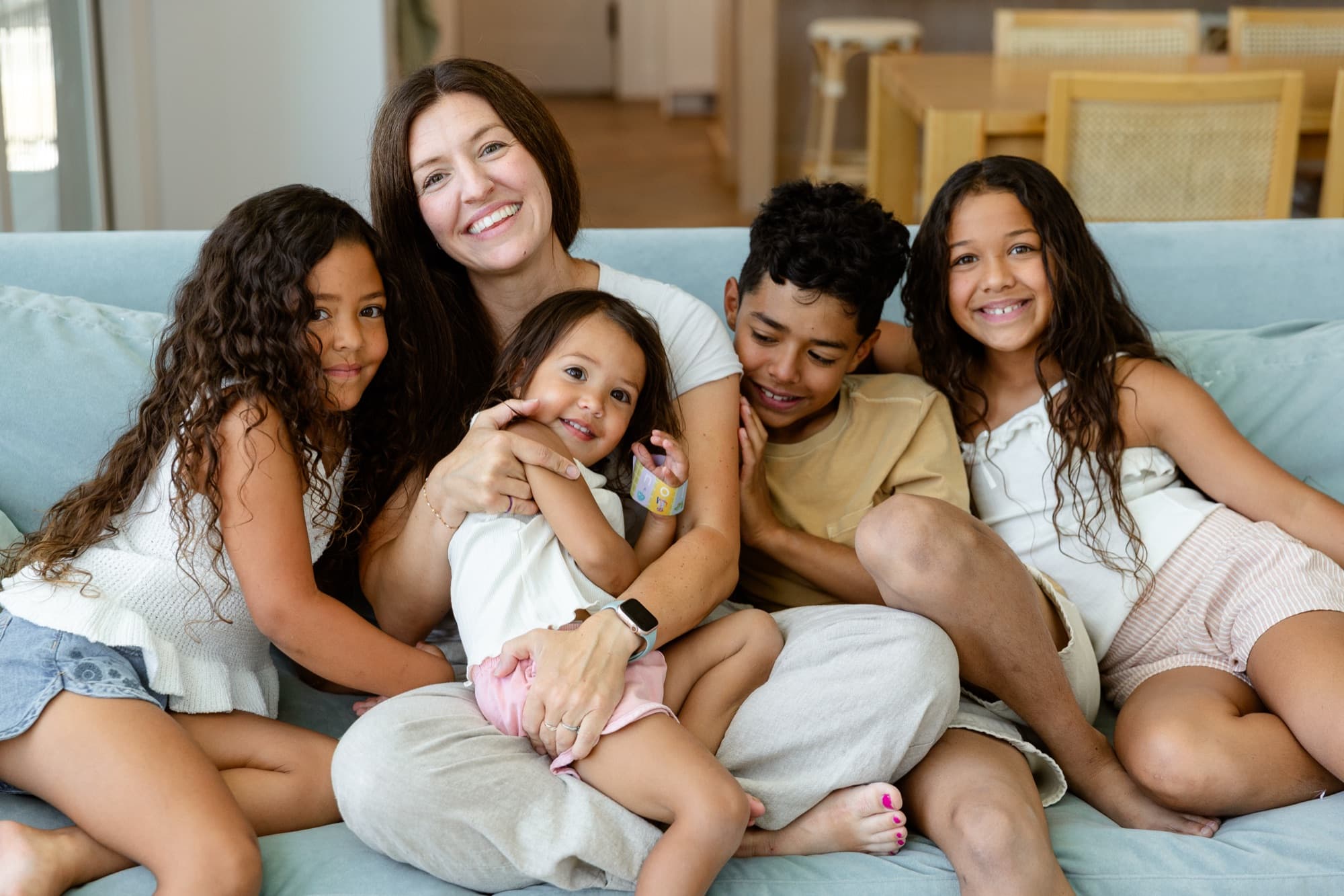Courtney Kalougata snuggled on the couch with her kids